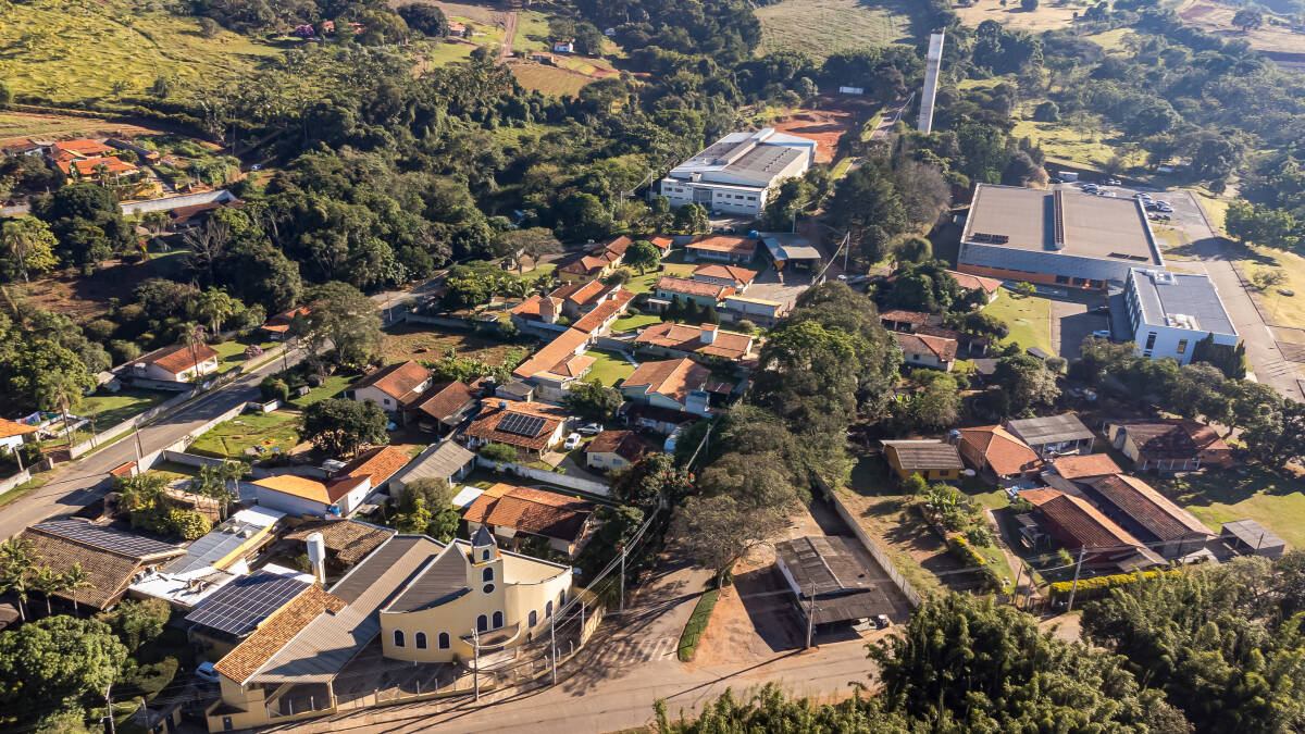 Vista aérea do bairro local com o galpão ao fundo.