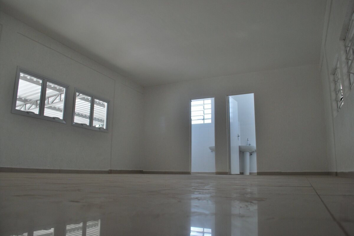 Escritório co piso em porcelanato e dois banheiros ao fundo.