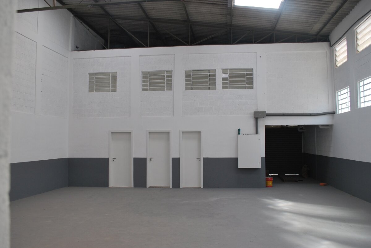 Vista interna do galpão, com janelas do escritório, ao fundo.