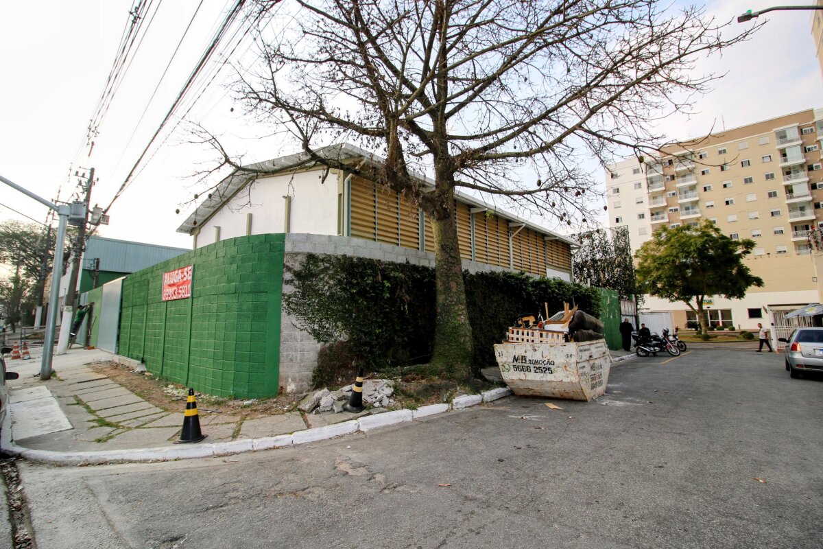 Vista externa lateral, com bonita paineira e entrada do Condomínio Atua Interlagos ao fundo.