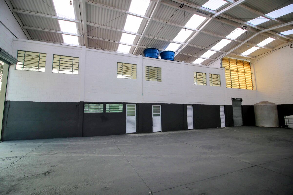 Vista interna do galpão, com vestiários e escritório ao fundo.