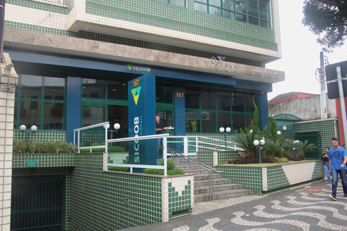 Entrada do edifício a partir da calçada da rua, com escadas.